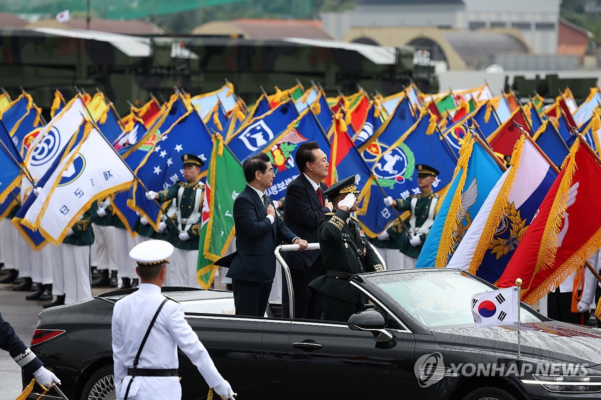 El presidente Yoon Suk Yeol (derecha) y el ministro de Defensa, Kim Yong-hyun (i), pasan revista a las unidades militares en una caravana durante una ceremonia que conmemora el 76º Día de las Fuerzas Armadas, celebrada en la Base Aérea de Seúl en Seongnam, al sur de Seúl, el 1 de octubre. 2024. (Foto de la piscina) (Yonhap)