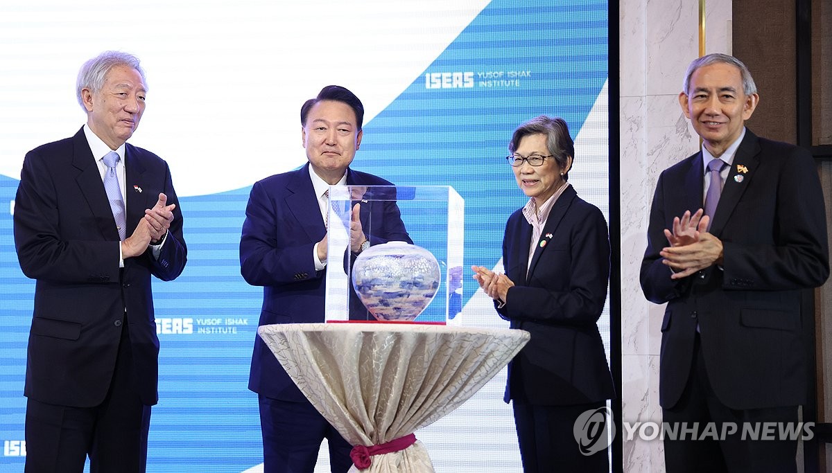 El presidente Yoon Suk Yeol (segundo por la izquierda) recibe un obsequio de cerámica de los paneles de la Conferencia de Singapur organizada por el Instituto de Estudios del Sudeste Asiático en Singapur el 9 de octubre de 2024. (Yonhap)