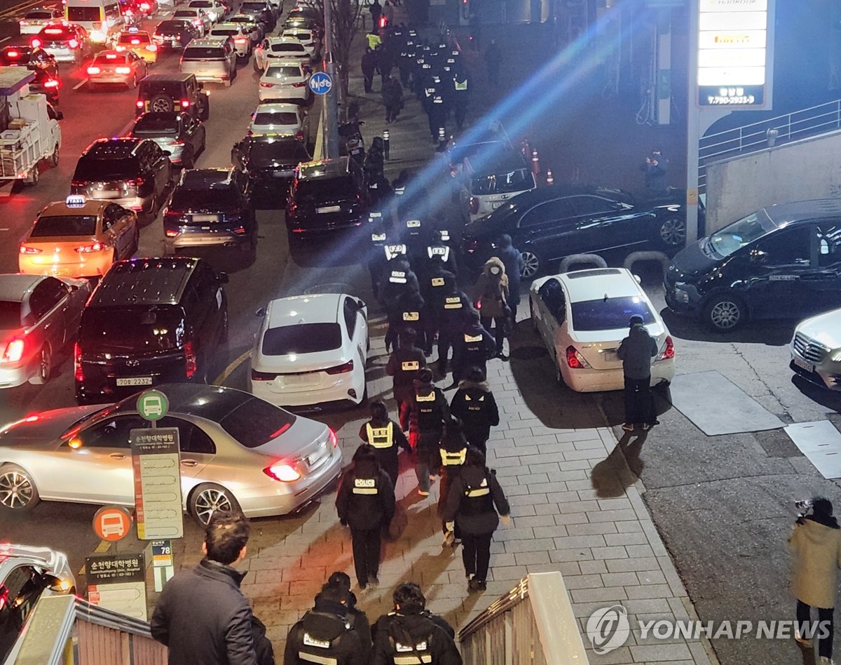 Agentes de policía caminan hacia la residencia oficial del presidente acusado Yoon Suk Yeol en Seúl el 15 de enero de 2025, mientras la policía y funcionarios de la agencia anticorrupción intentan nuevamente ejecutar una orden para detener a Yoon en relación con su breve imposición de la ley marcial. . (Yonhap)