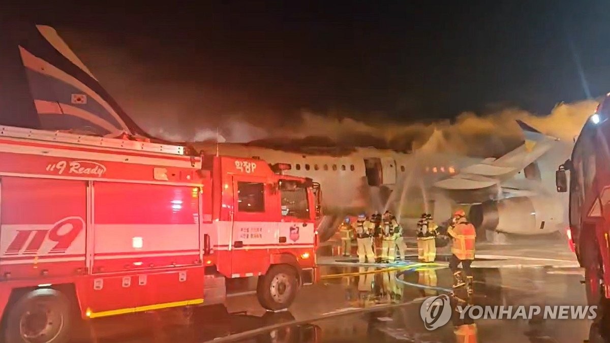 En esta foto proporcionada por un lector, los bomberos están tratando de apagar el incendio en un avión de Busan en el aeropuerto internacional de Gimhae en Busan, a 320 kilómetros al sureste de Seúl, el 28 de enero de 2025. (Foto no para la venta) (Yonhap)